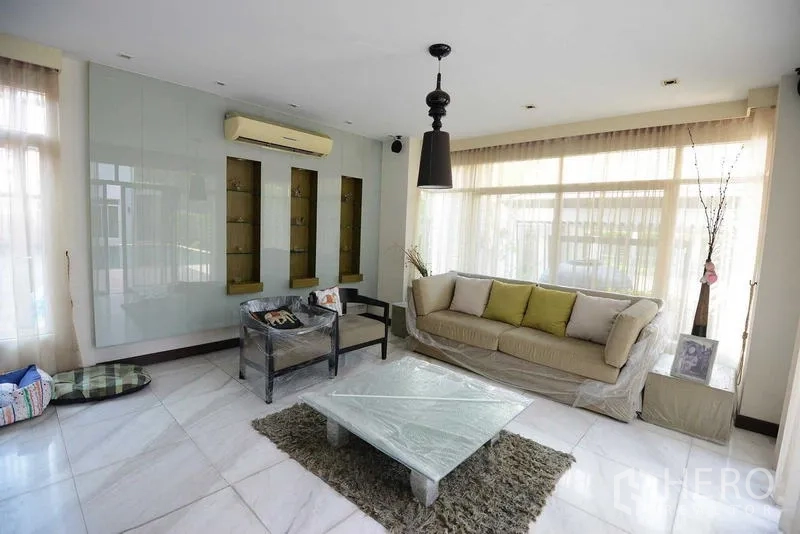 Detached House for sale in Bang Kapi, Bangkok - Light-filled living room with built-in display wall, sofa set and glossy marble tiles