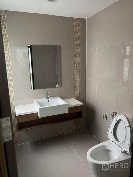 Home Office for rent in Bang Phli, Samut Prakan - Contemporary bathroom with wall tiles, vanity sink, mirror and toilet.