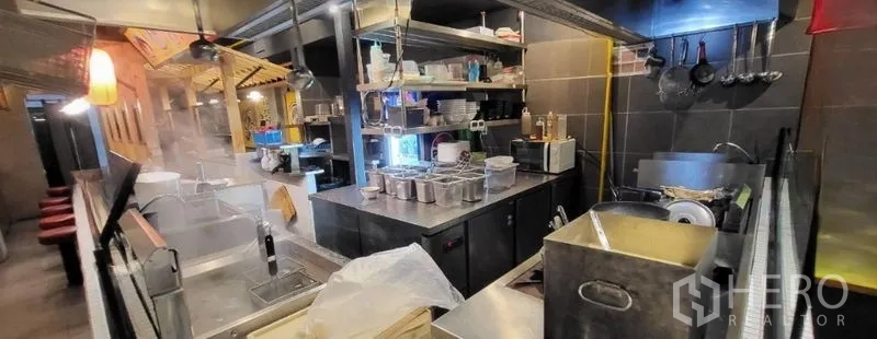店屋 出租在Khlong Toei, Bangkok - 商用厨房，配不锈钢操作台、排烟罩与收纳架。