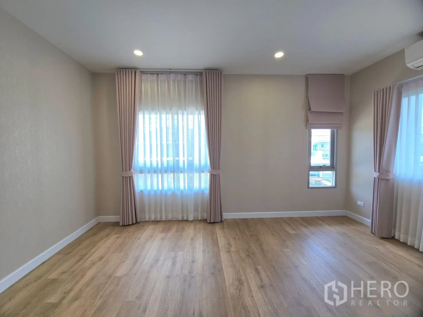 Detached House for rent in Lat Krabang, Bangkok - Empty bedroom with wood floors, recessed lights and soft drapes.