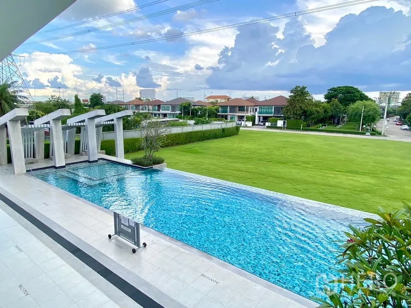 บ้าน ให้เช่าในPrawet, Bangkok - สระว่ายน้ำส่วนกลางพร้อมทางเดินริมสระ มองเห็นสนามหญ้าและหมู่บ้าน