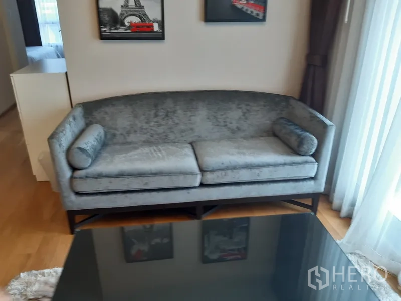 คอนโด ให้เช่าในWatthana, Bangkok - โซฟาผ้าสีเทาสองที่นั่งข้างหน้าต่างสูงจรดเพดาน