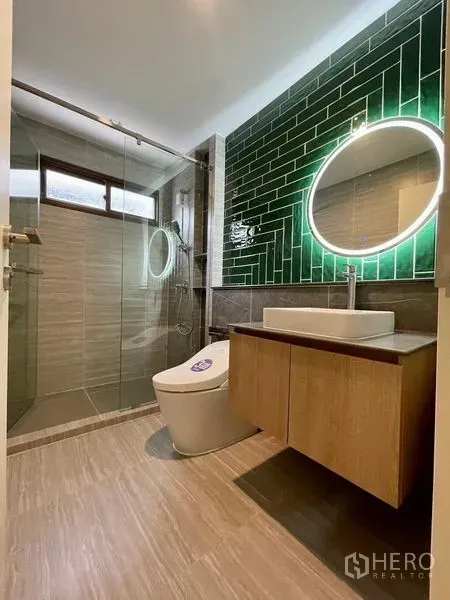 独立式住宅 出售在Bang Kapi, Bangkok - 现代卫浴，玻璃淋浴间、绿色地铁砖背景墙、背光圆镜与悬空洗手台。