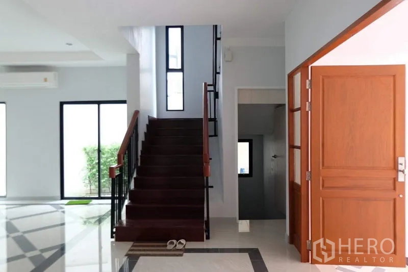 Detached House for sale in Bang Phli, Samut Prakan - Entry hall with solid wood door and staircase with wooden steps and handrail.