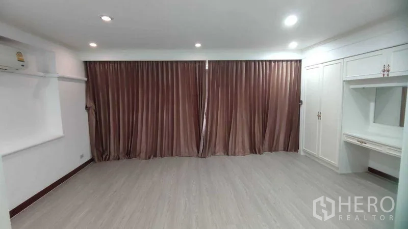 Home Office for rent in Watthana, Bangkok - Large bedroom with blackout curtains, recessed lighting and built-in storage.