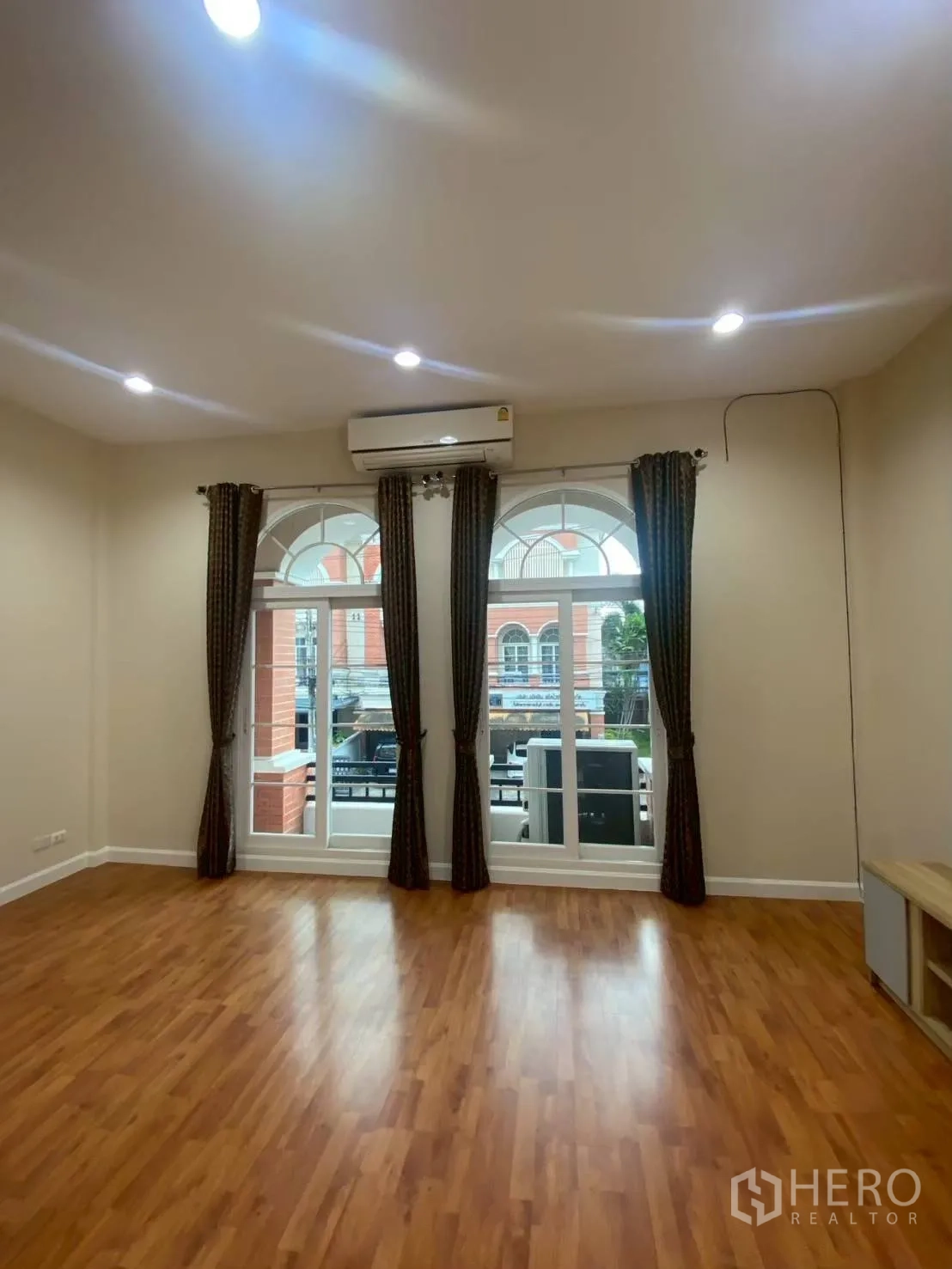 Townhouse for rent in Bang Kapi, Bangkok - Living room with large arched windows and curtains.
