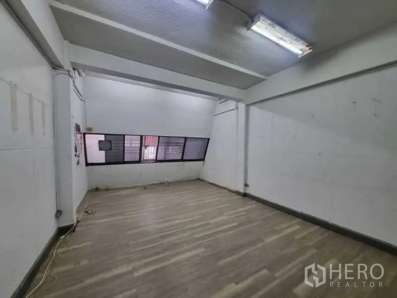 店屋 出租在Watthana, Bangkok - 楼上房间，木纹地板与长条斜窗。