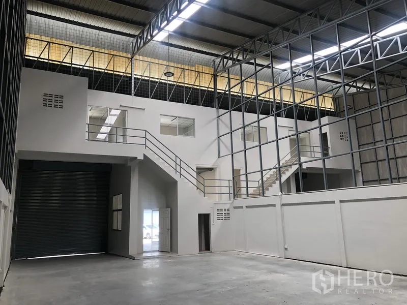 Factory for rent in Pak Kret, Nonthaburi - High-clear warehouse with twin mezzanine offices and metal truss roof.