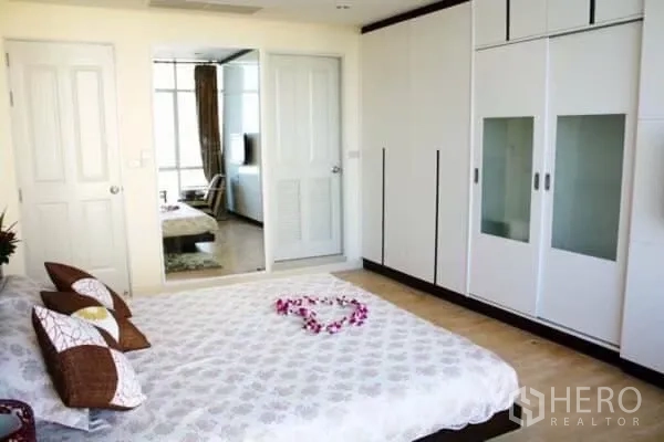คอนโด ให้เช่าในKhlong San, Bangkok - ห้องนอนสว่าง เตียงคู่ ตู้เสื้อผ้าบิวท์อินสีขาว และประตูกระจกบานเลื่อน