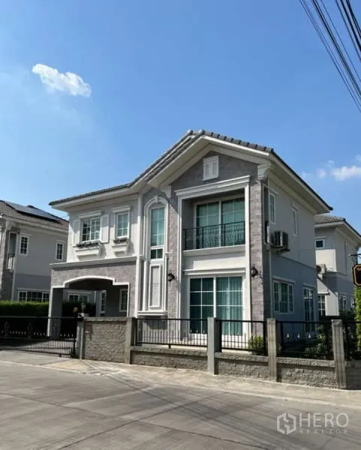 บ้าน ให้เช่าหรือขายในKhan Na Yao, Bangkok - มุมมองจากถนนของบ้านสองชั้นสไตล์หรู พร้อมรั้ว ระเบียง และผนังหิน