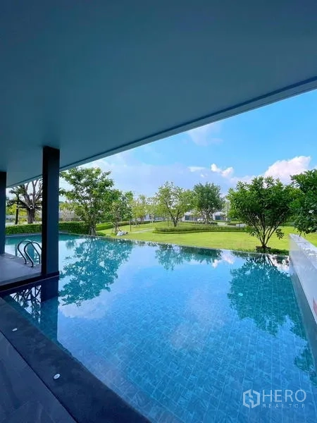 Townhouse for rent in Bang Phli, Samut Prakan - Swimming pool beside garden with open pavilion and blue tiles.