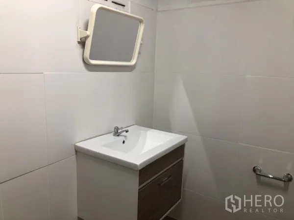 Warehouse for rent in Wang Thonglang, Bangkok - Restroom with vanity, mirror, and tiled walls.