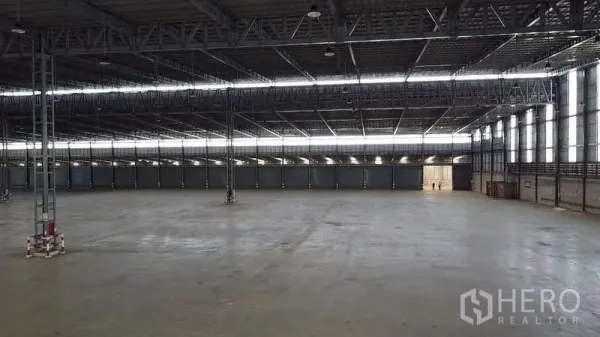 Warehouse for rent in Bang Phli, Samut Prakan - Clear-span warehouse hall with strip skylights, wide column bays, and smooth concrete flooring.