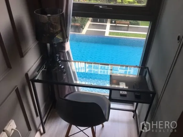 Condominium for rent in Phra Khanong, Bangkok - Window workstation with glass desk overlooking the condominium swimming pool