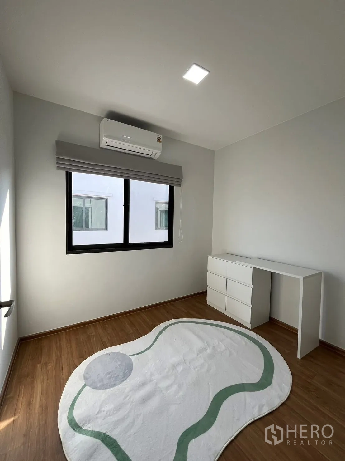 联排别墅 出租在Bang Phli, Samut Prakan - 明亮卧室，木地板，空调，窗户与白色书桌抽屉。