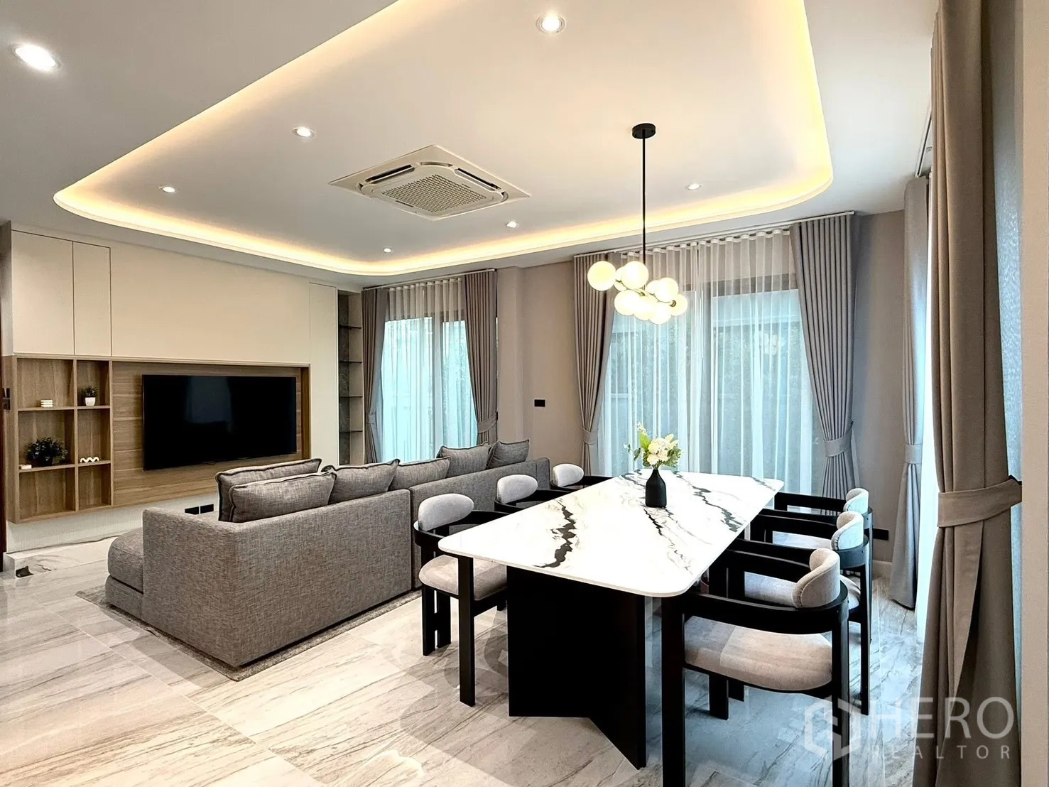 บ้านแฝด for rent in Bang Phli, Samut Prakan - ห้องนั่งเล่นเชื่อมรับประทานอาหาร โต๊ะท็อปหินอ่อน โซฟา ผนังทีวี และไฟซ่อนฝ้า