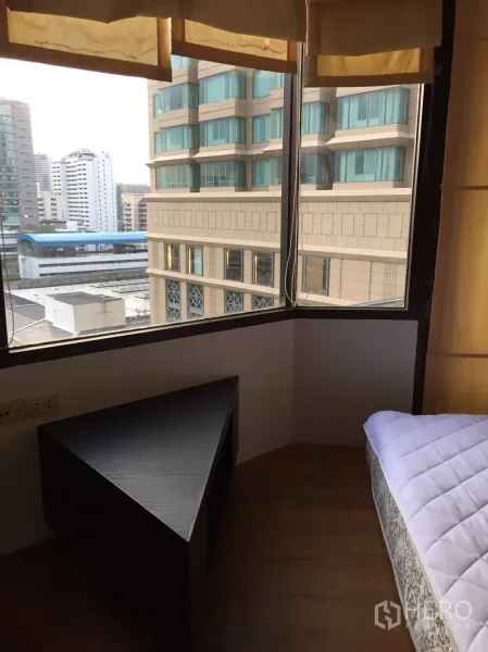 คอนโด ให้เช่าในPathum Wan, Bangkok - มุมห้องนอนพร้อมหน้าต่างบานใหญ่ เห็นวิวเมือง และโต๊ะทรงสามเหลี่ยมข้างเตียง