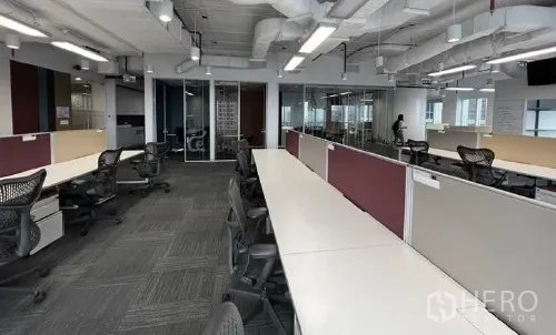 Office Space for rent - Open-plan office in Pathum Wan, Bangkok with long bench desks, ergonomic chairs and glass meeting rooms.