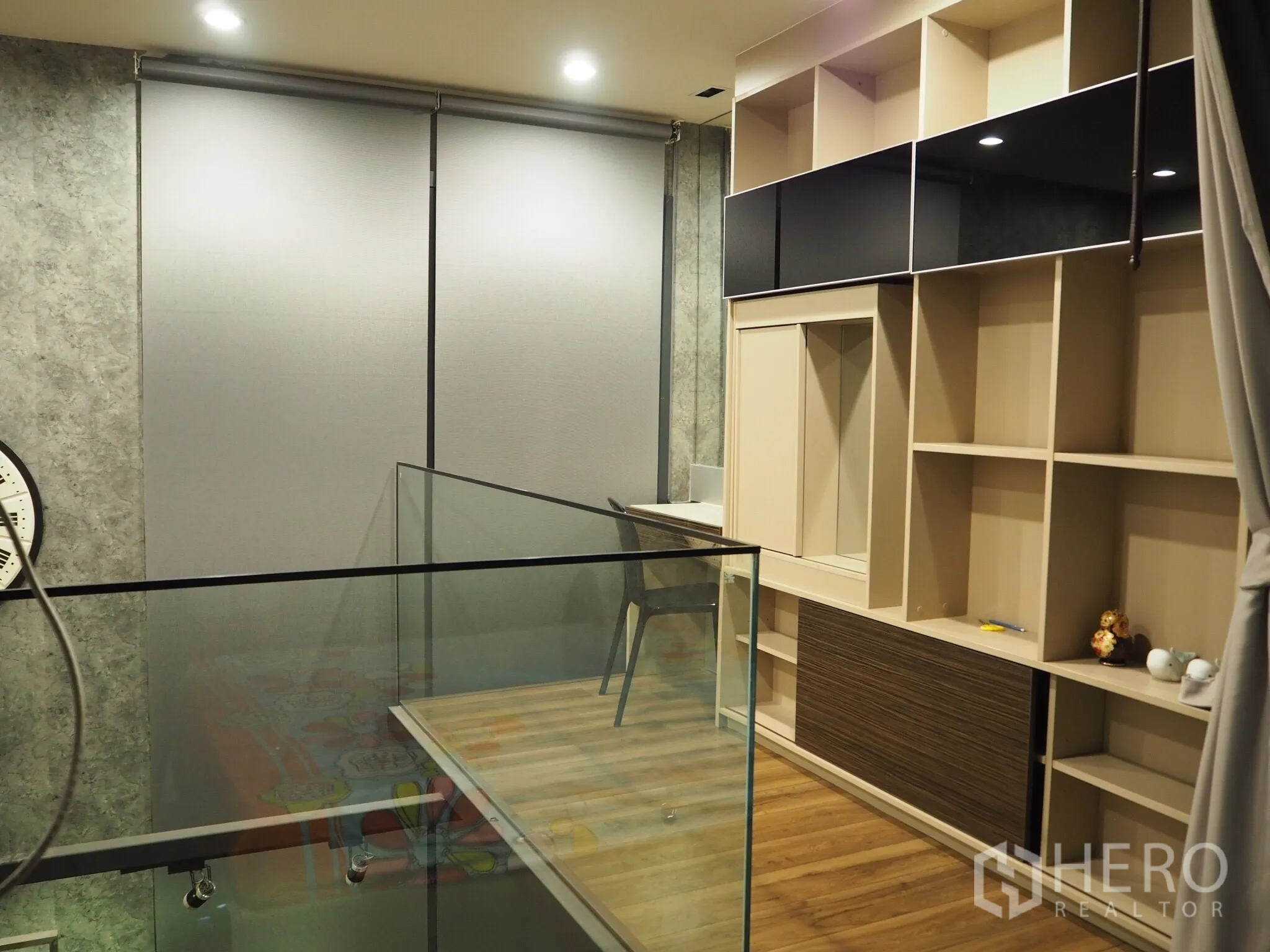 Condominium for rent in Phaya Thai, Bangkok - Upper mezzanine with full-height cabinetry, work desk and glass railing overlooking the living area.