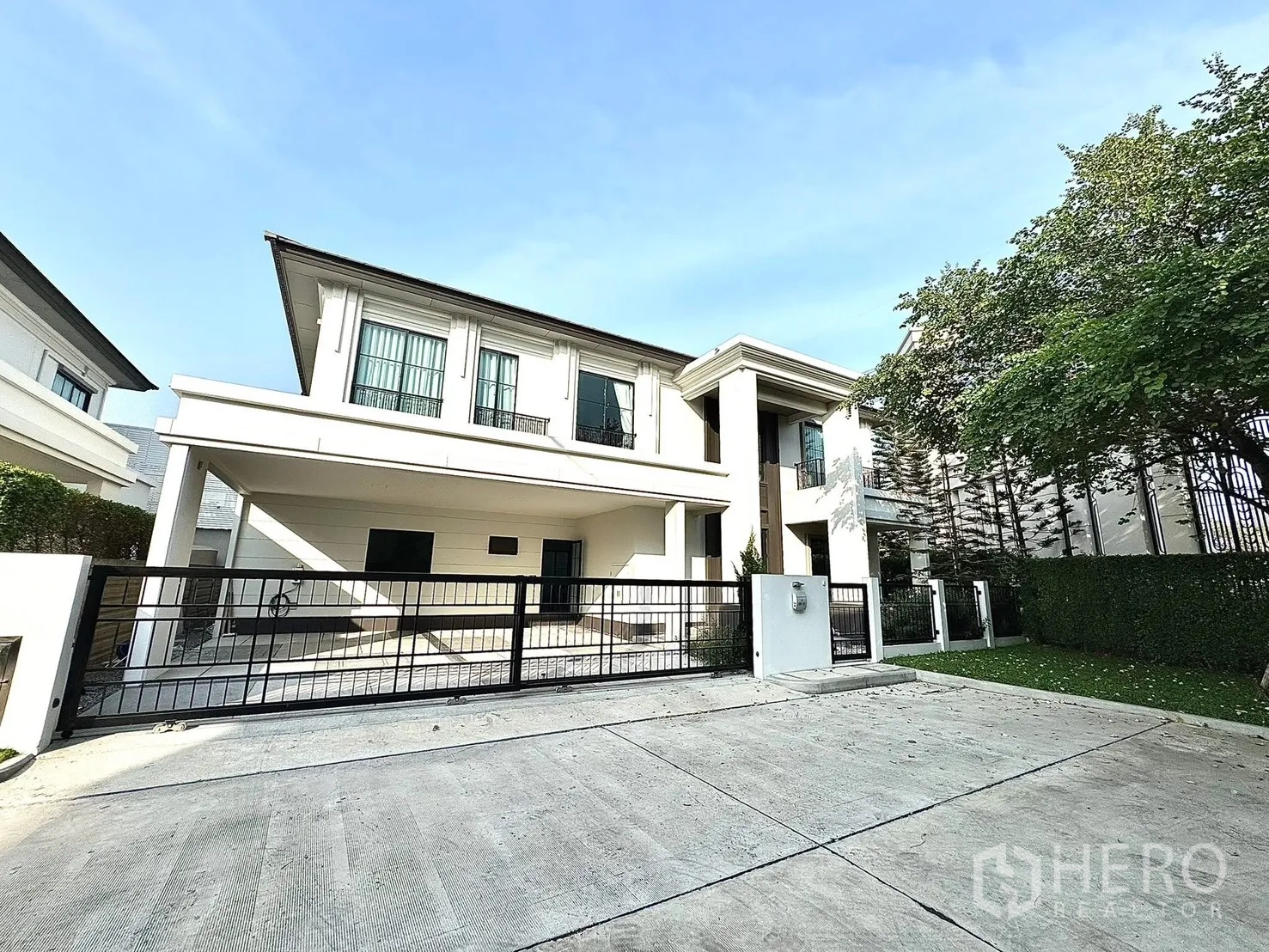 Detached House for rent in Bang Phli, Samut Prakan - Modern two-story detached house with gated driveway, covered carport and manicured hedge.