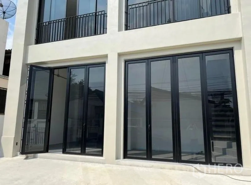 带办公室的家 出租或出售在Bang Na, Bangkok - 一层外立面，黑框折叠玻璃门