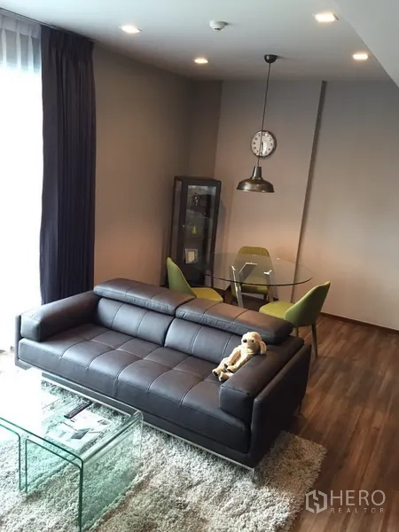 คอนโด ให้เช่าในWatthana, Bangkok - มุมนั่งเล่นมีโซฟาหนัง โต๊ะกลางกระจก และชุดทานอาหารทรงกลมกับโคมไฟแขวน