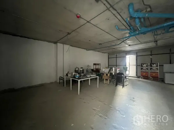 พื้นที่ขายปลีก ให้เช่า - พื้นที่ภายในสภาพเปล่าขนาดใหญ่ พื้นคอนกรีต เดินท่อที่เพดาน และโต๊ะเก็บของชั่วคราว