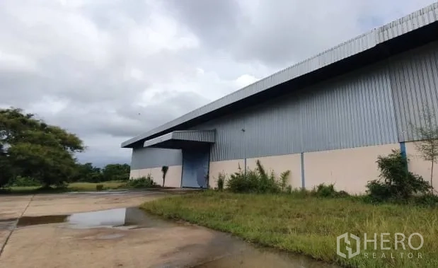 คลังสินค้า ให้เช่าในChaloem Phra Kiat, Nakhon Ratchasima - มุมมองด้านข้างของโกดังโครงเหล็ก ติดสนามหญ้าและลานรถบรรทุกกว้าง