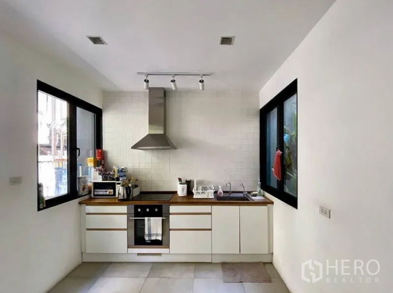 ทาวน์เฮาส์ ให้เช่าในKhlong Toei, Bangkok - ครัวสีขาวสว่างบิวท์อิน เตาอบ เครื่องดูดควัน และหน้าต่างสองด้าน