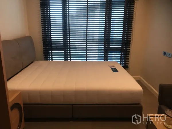 คอนโด ให้เช่าในKhlong Toei, Bangkok - ห้องนอนสว่าง เตียงควีน ม่านบังแสง และผนังโทนอบอุ่นในคอนโดย่านสุขุมวิท