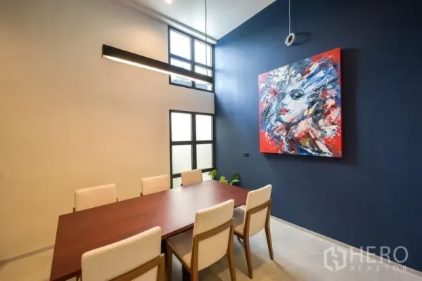 Home Office for rent or sale - Modern dining or meeting room with high ceiling, blue feature wall and abstract artwork.