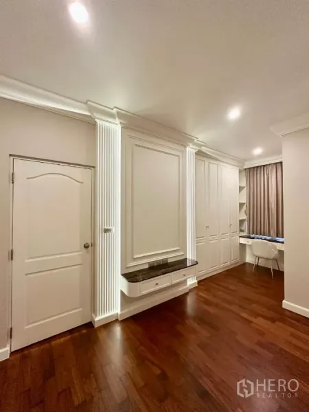 Townhouse for rent in Bang Kho Laem, Bangkok - Bright multipurpose room with white built-in cabinetry, desk and warm wood flooring