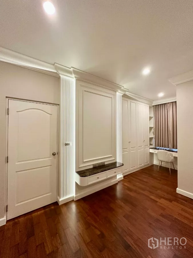 Townhouse for rent in Bang Kho Laem, Bangkok - Bright multipurpose room with white built-in cabinetry, desk and warm wood flooring