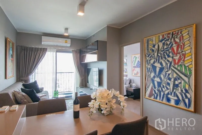Condominium for rent in Phra Khanong, Bangkok - Dining area facing the balcony and TV lounge with sliding glass doors.