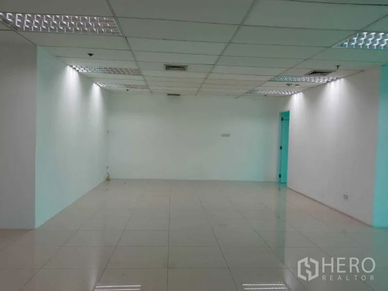 Office Space for rent in Huai Khwang, Bangkok - Wide open office area with white walls, overhead lighting and polished flooring.