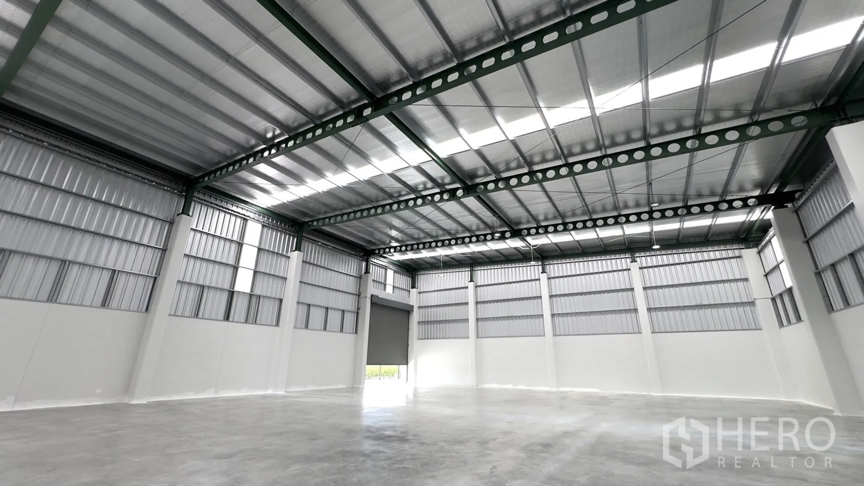 工厂 出租或出售在Bang Yai, Nonthaburi - 仓库内部，高挑保温屋顶、钢梁结构与抛光混凝土地面。