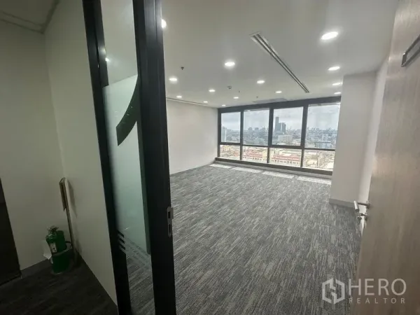 Office Space for rent in Khlong Toei, Bangkok - Private office with panoramic windows, grey carpet and skyline views beyond a sliding glass door.