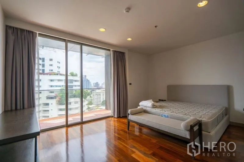 คอนโด ให้เช่าในKhlong Toei, Bangkok - ห้องนอนมุม กระจกบานเลื่อนเต็มผืน เปิดออกสู่ระเบียง พื้นไม้ และวิวเมือง