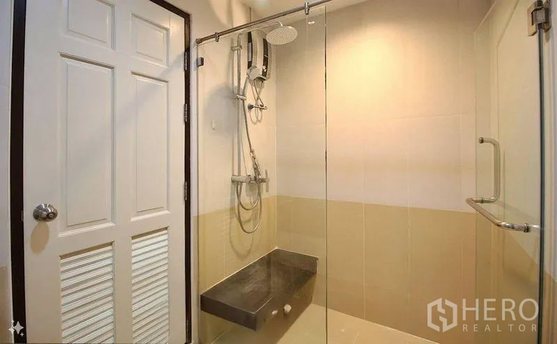 Condominium for sale in Watthana, Bangkok - Modern bathroom with glass-enclosed shower, rain showerhead and water heater.