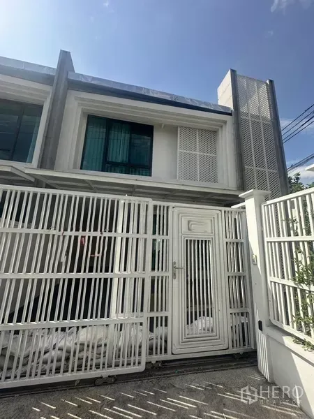 Townhouse for rent in Watthana, Bangkok - Modern two-storey townhouse facade with white metal gate in Watthana, Bangkok.