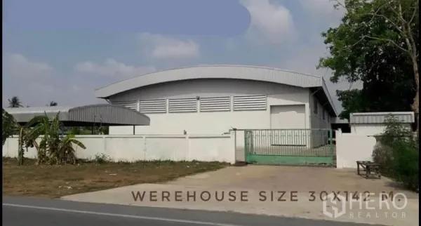 货栈 出租或出售 - 白色弧形屋顶仓库正面，带大门与临路出入口