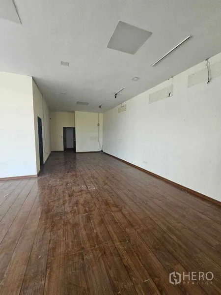 带办公室的家 出租在Prawet, Bangkok - 宽敞大厅另一角，木地板与白墙。