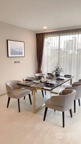 公寓 出租在Watthana, Bangkok - 餐区临大窗，六人餐桌可观城市景致与柔和窗帘。