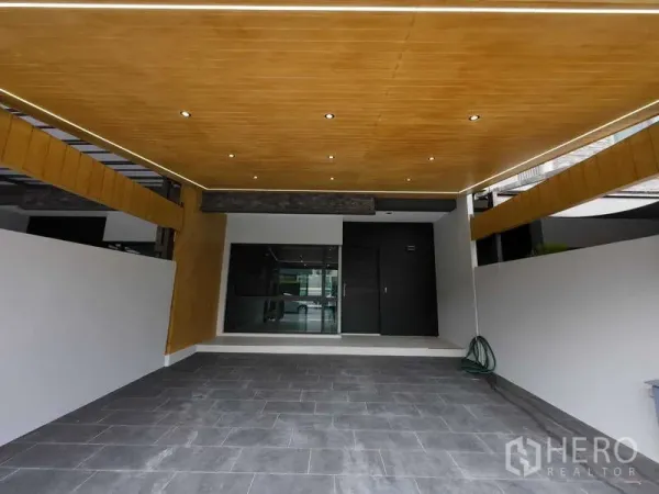 联排别墅 出租或出售在Lat Phrao, Bangkok - 再次展示带顶棚车库，木质天花与灰色地砖。