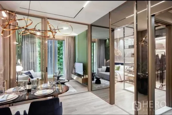 Condominium for sale in Bang Kho Laem, Bangkok - Open‑plan dining with modern chandelier, mirrored wardrobes and glass partitions to a bright lounge.