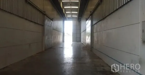 คลังสินค้า ให้เช่าในPathum Thani - ทางเดินอุตสาหกรรมพื้นคอนกรีต มีประตูบานม้วนเปิดออกสู่ภายนอก