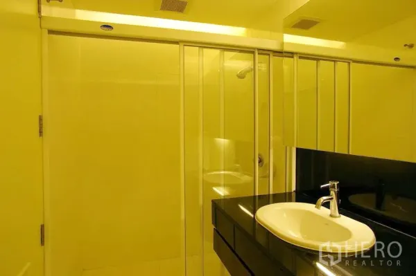 公寓 出租在Watthana, Bangkok - 现代浴室，玻璃淋浴房、大镜柜与黑色台面上的白色盆。