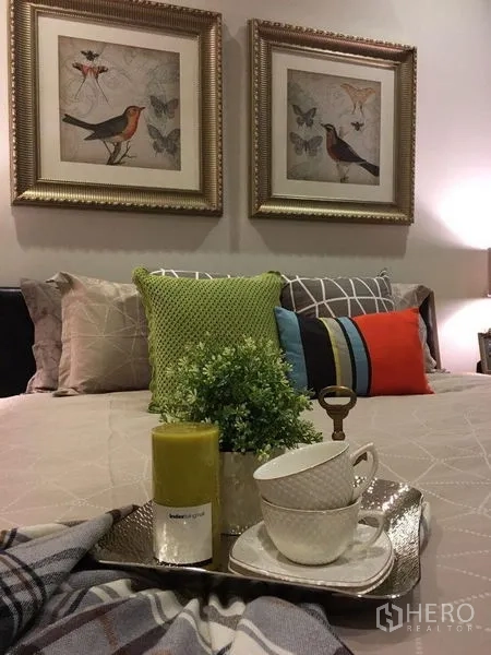 คอนโด ให้เช่าในWatthana, Bangkok - ภาพระยะใกล้ของเตียงตกแต่ง หมอนสีสัน กรอบรูปนก และถาดเสิร์ฟชา