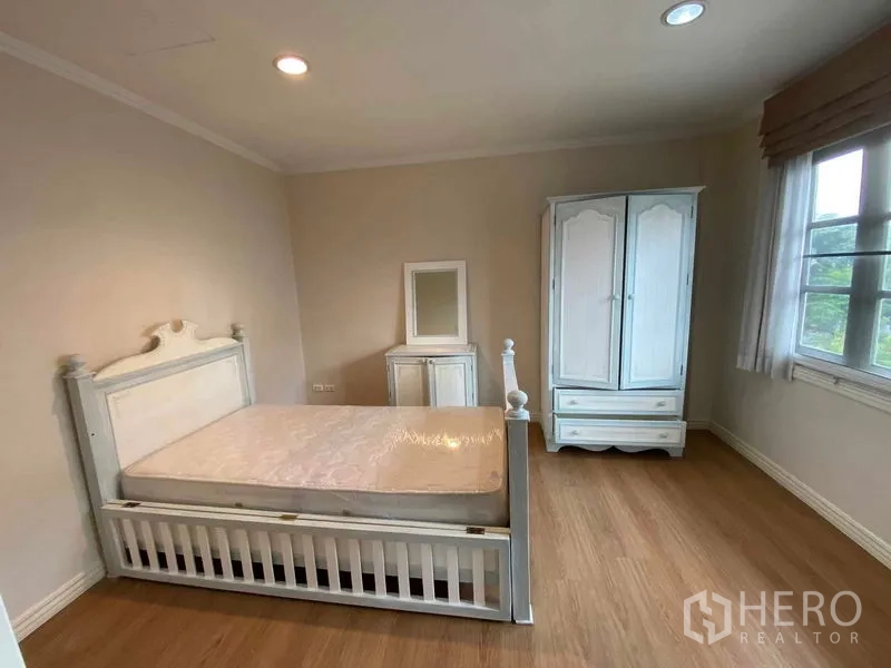 联排别墅 出租或出售在Mueang Samut Prakan, Samut Prakan - 明亮卧室，白色床与衣柜，木地板与窗户。