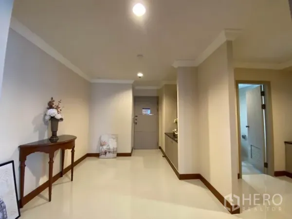 Condominium for rent in Watthana, Bangkok - Bright entry hallway with console table, cream walls and access to a bathroom.